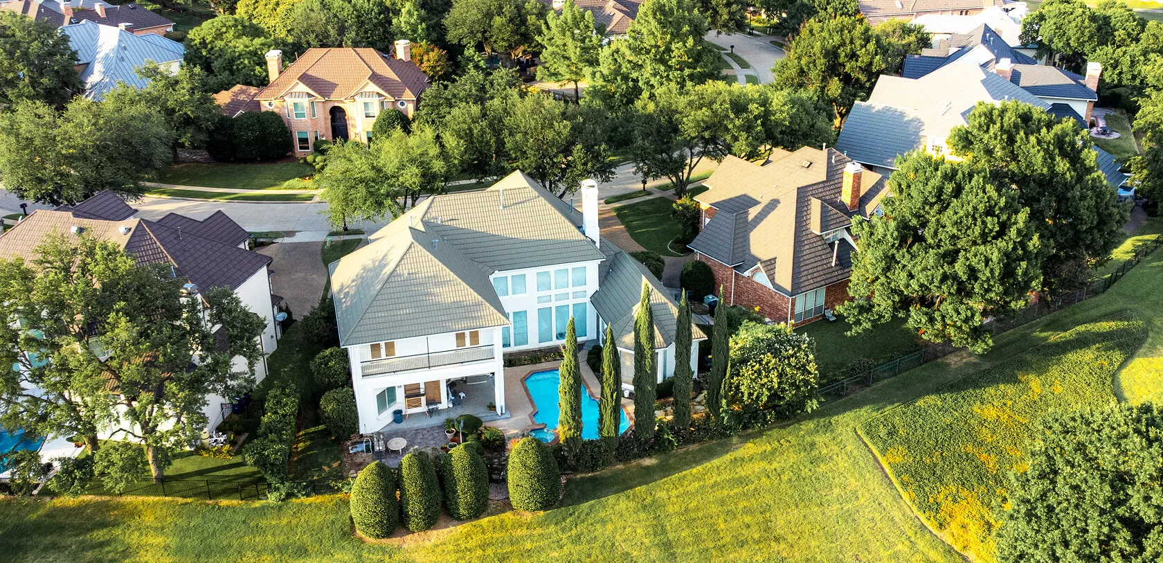 Aerial view of suburban homes with a backyard pool