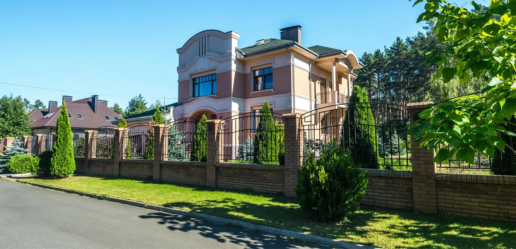 Close-up of a uniquely designed house exterior showcasing detailed brickwork, distinctive architecture, and landscaped surroundings.