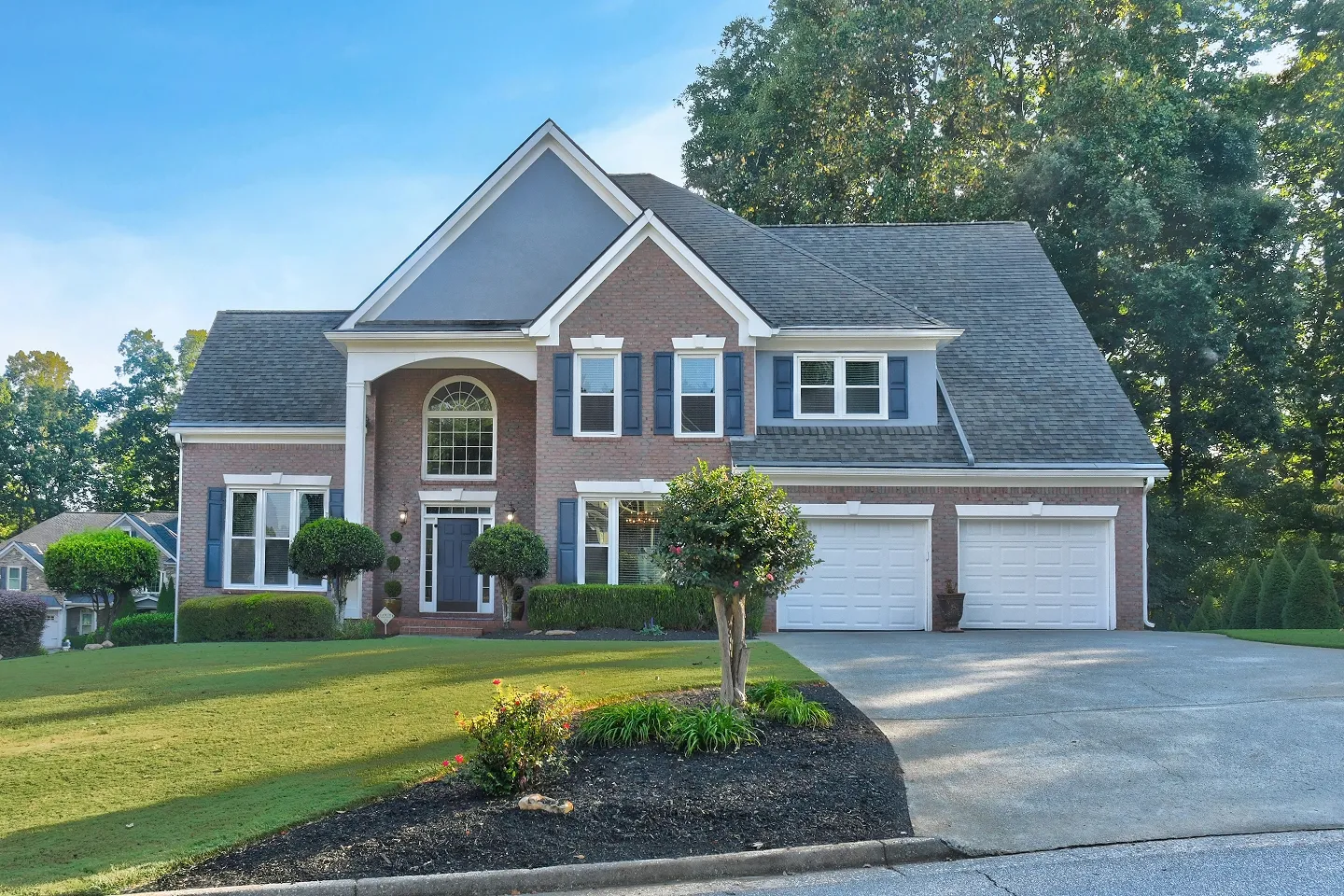 Modern blue house with a car garage and stone accents, a professional curb appeal photo in Atlanta.