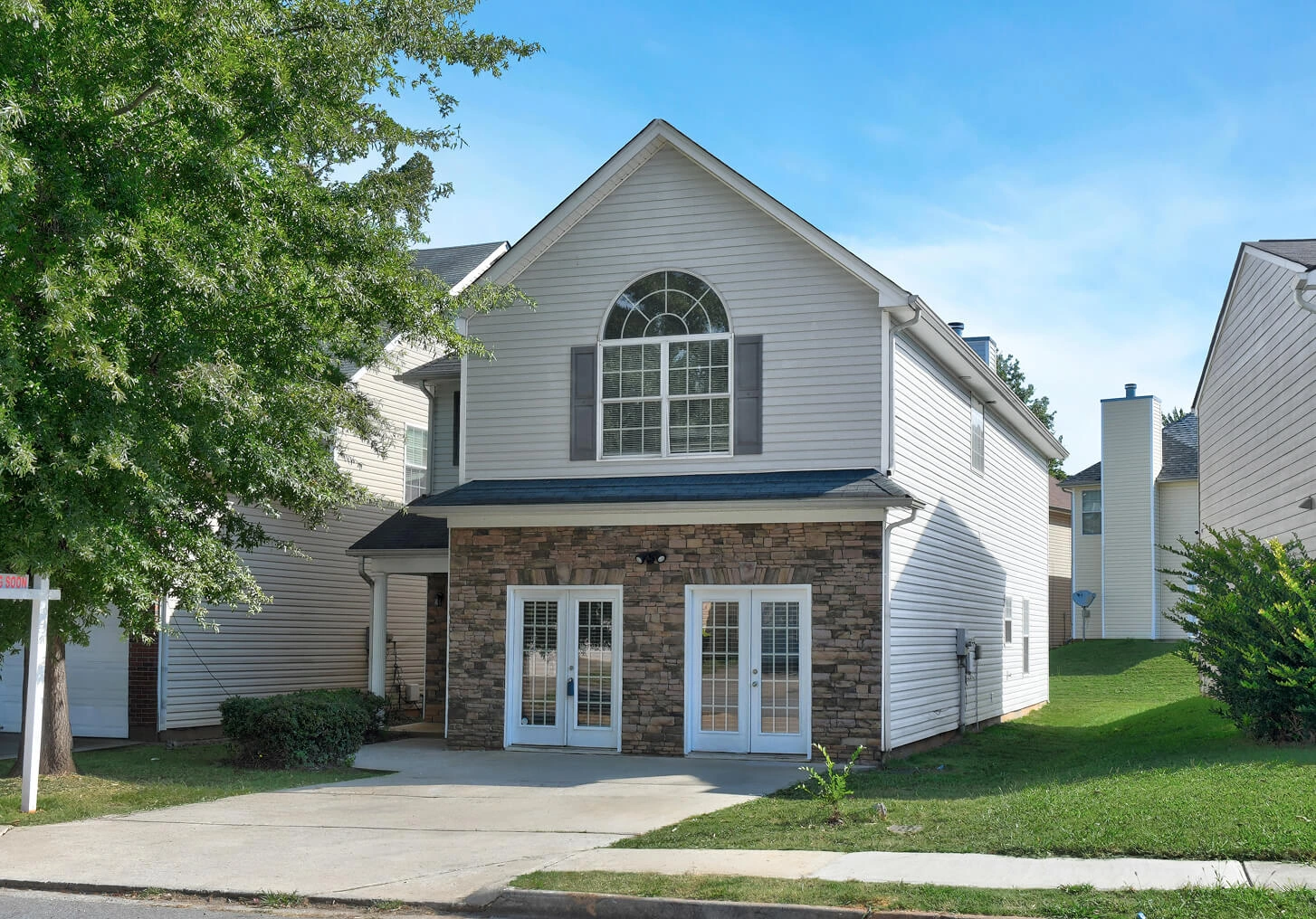 Traditional two-story home exterior with light siding and a dark garage door, professionally photographed for a real estate listing in Atlanta.