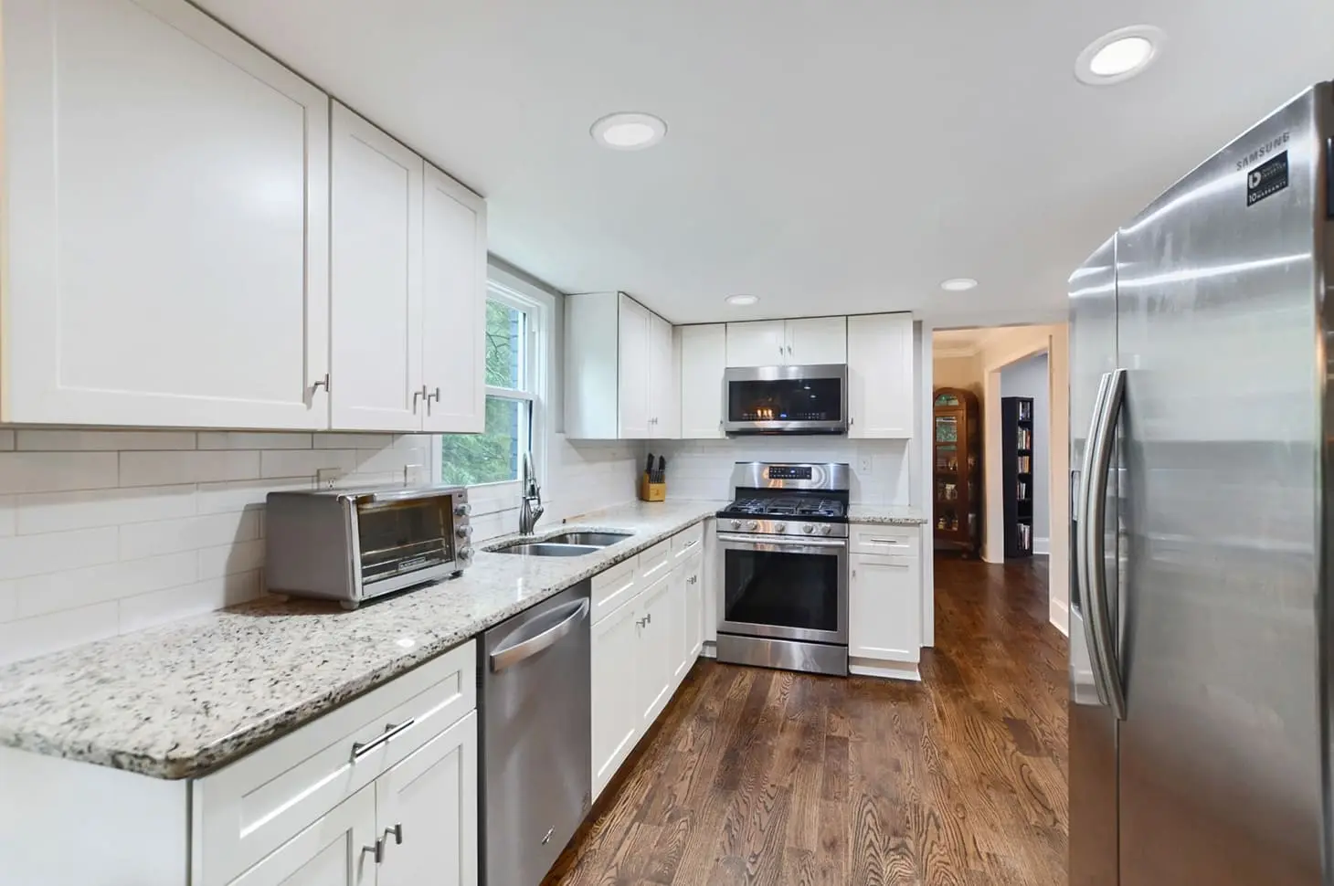 Close-up view of a modern kitchen featuring white shaker cabinets, white countertops, and stainless steel range, representing the AI-enhanced after version.