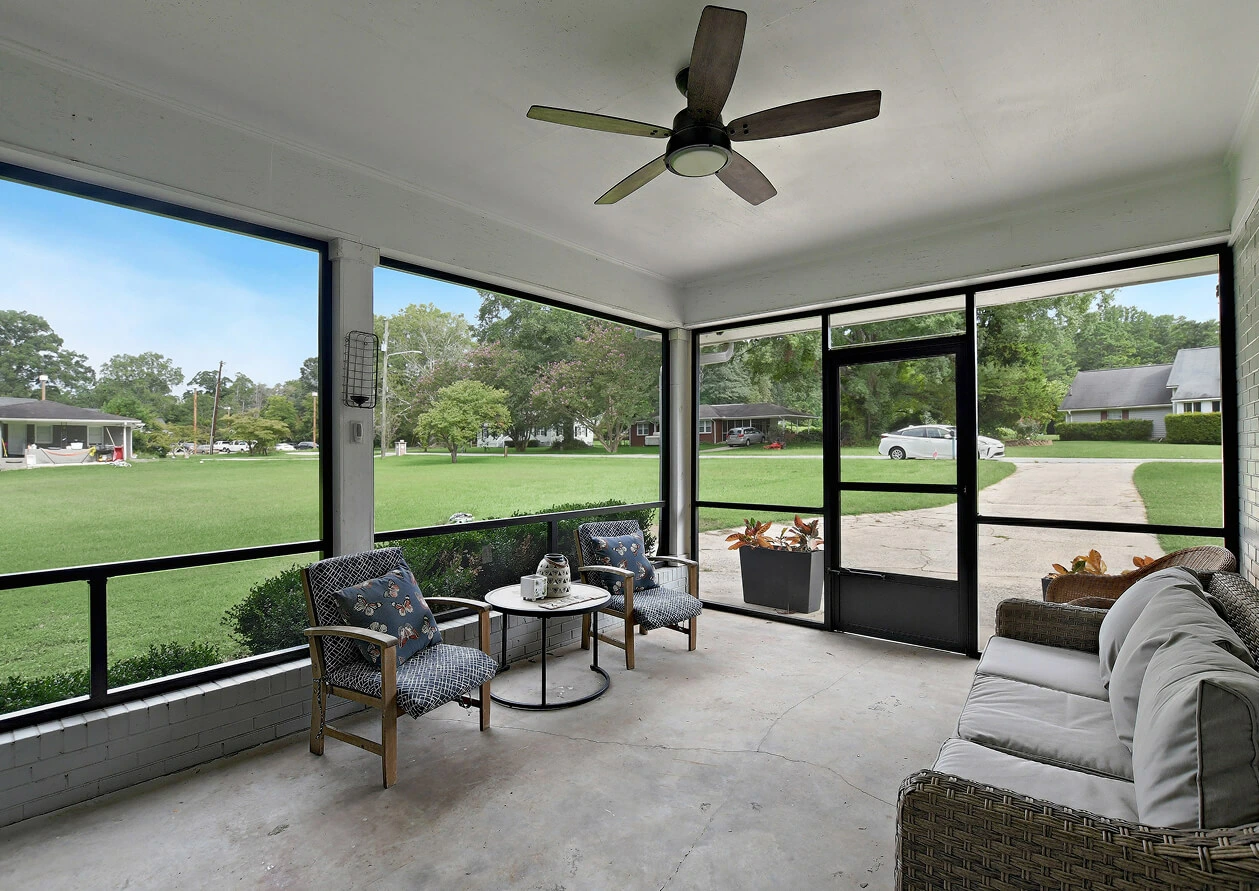 Inviting screened-in outdoor porch with comfortable seating, highlighting a relaxing outdoor living space for a property listing.